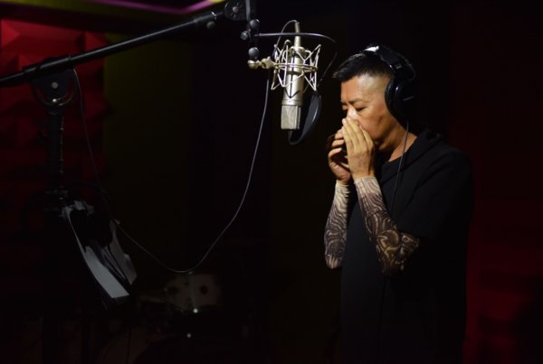 彝族知名歌手吉克曲布在录音室吹奏口弦